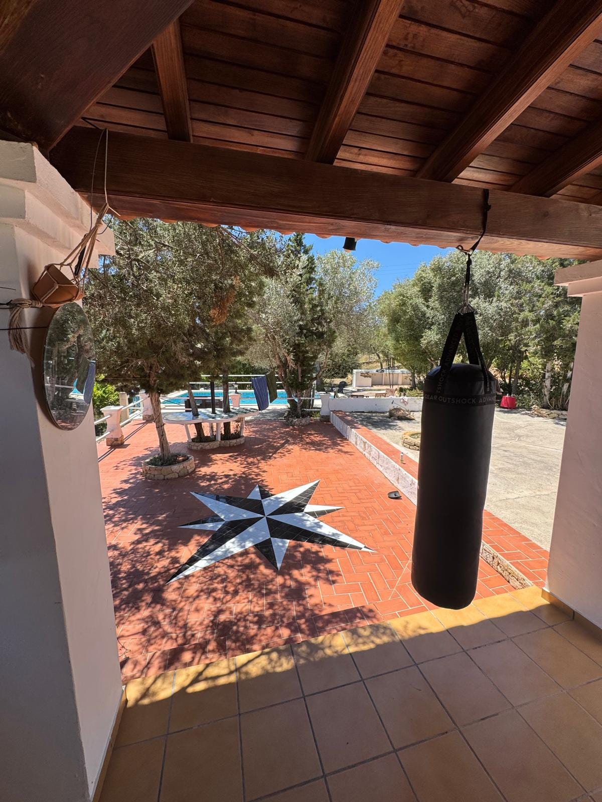Covered terrace with compass rose tile and punching bag